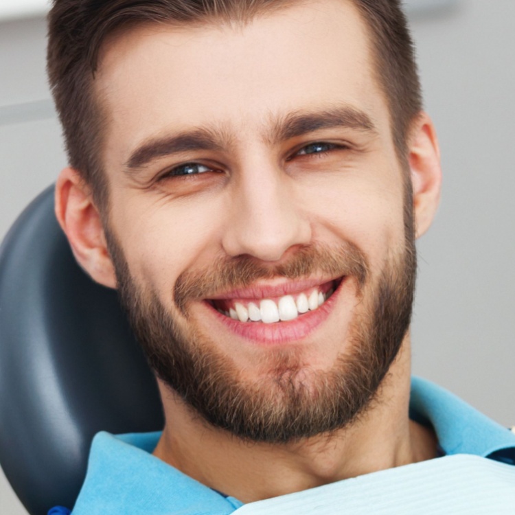Paciente sonriendo despues de recibir un empaste dental en la clinica