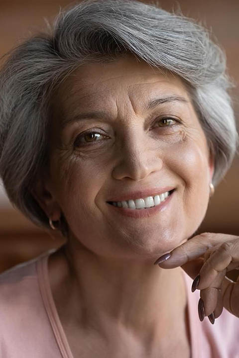 mujer con sonrisa restaurada despues de recibir un procedimiento de implantes dentales