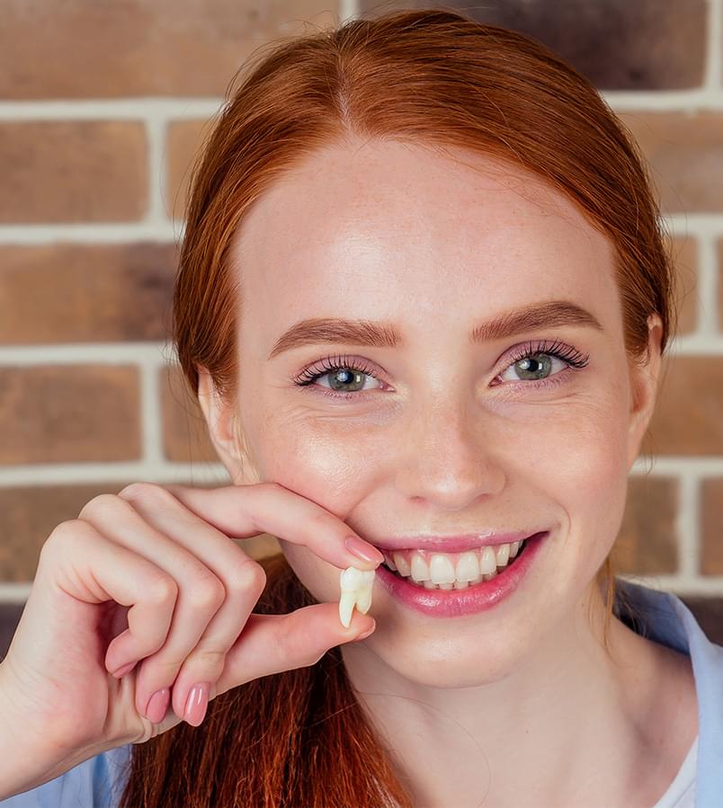patient with tooth after removal